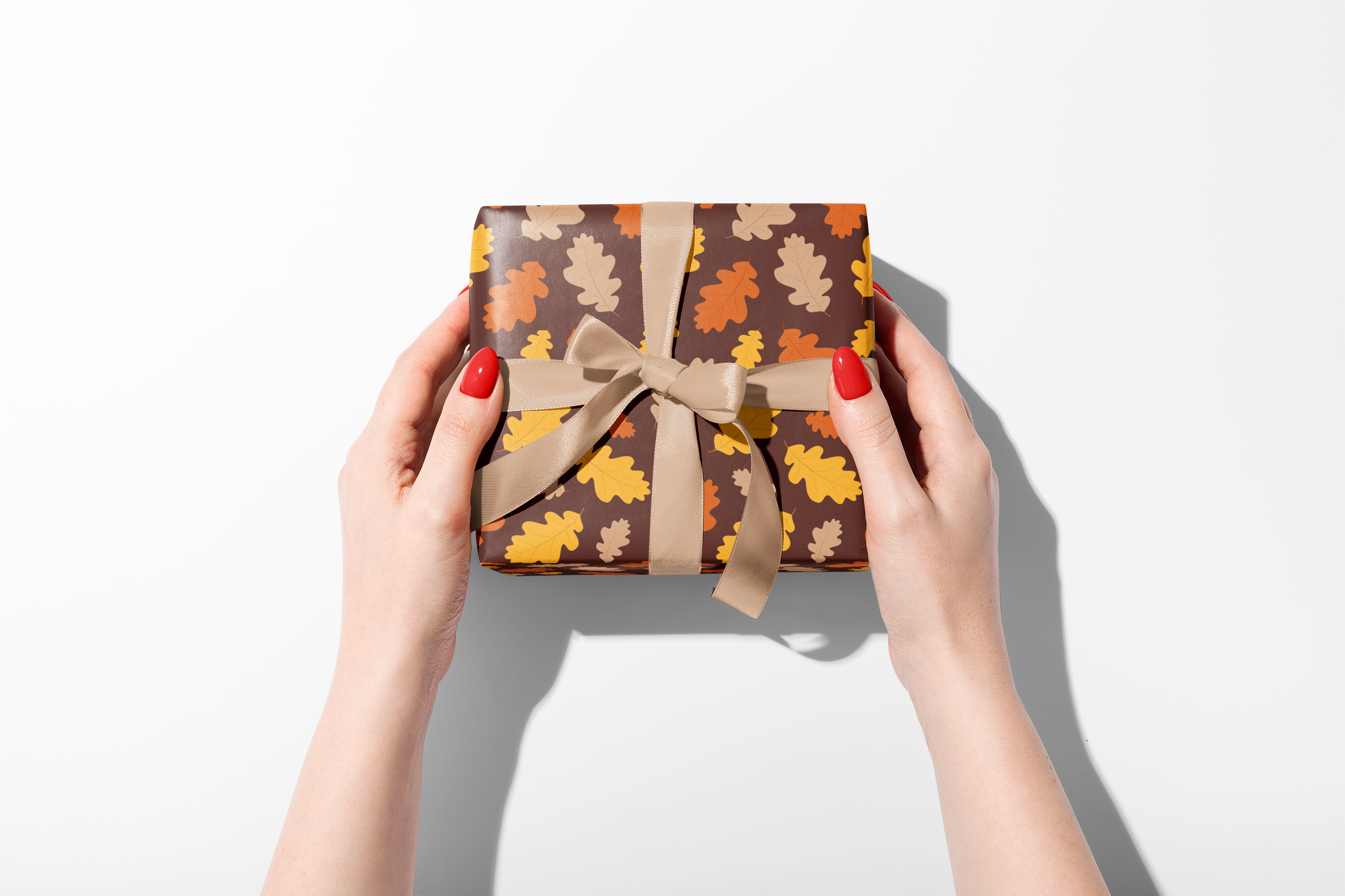 Dense fall wrapping paper with a scattered pattern of stylized leaves in burnt orange, brown, and yellow, ideal for autumn and Thanksgiving gifts.
