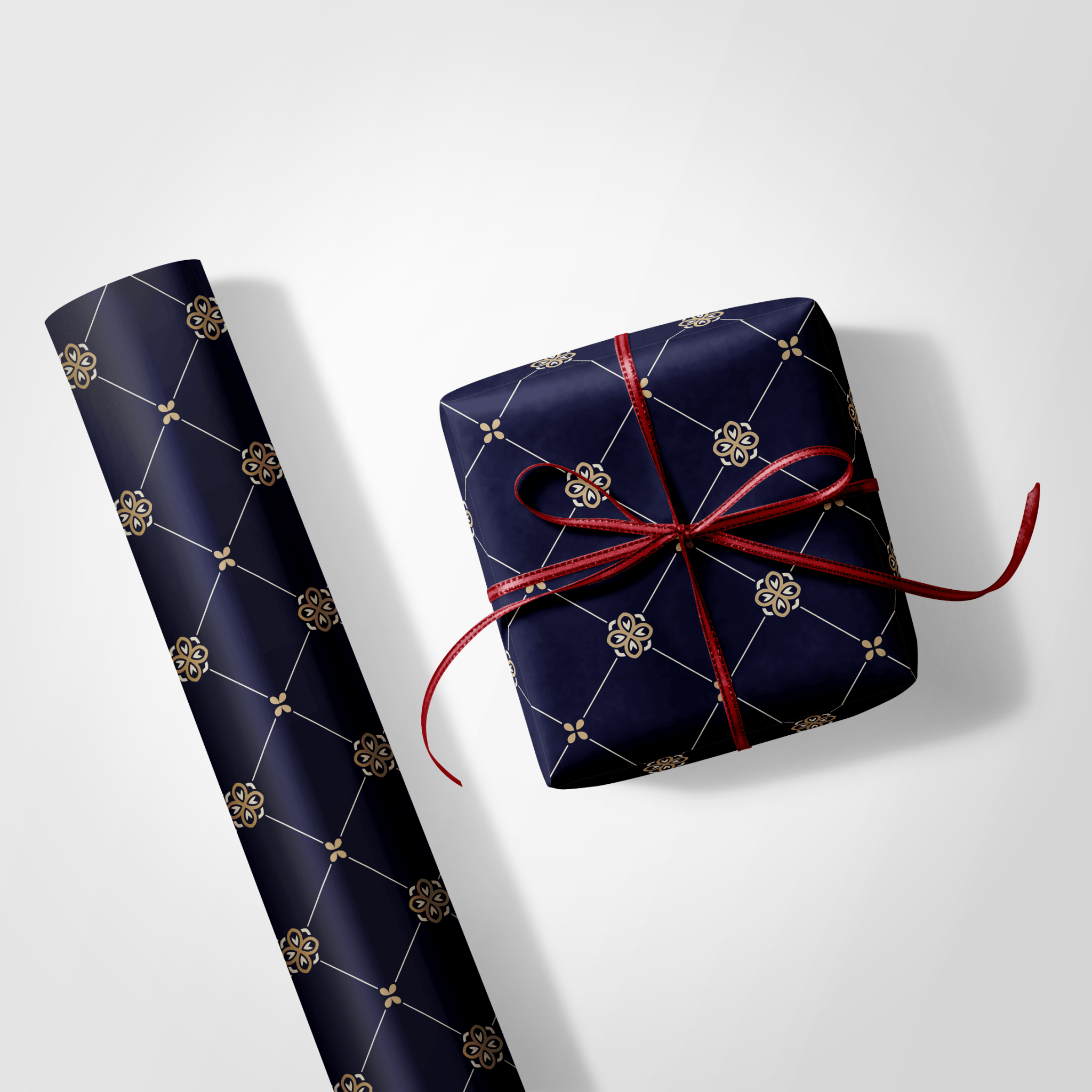 Navy blue gift wrap with gold patterns and a red ribbon on a white background