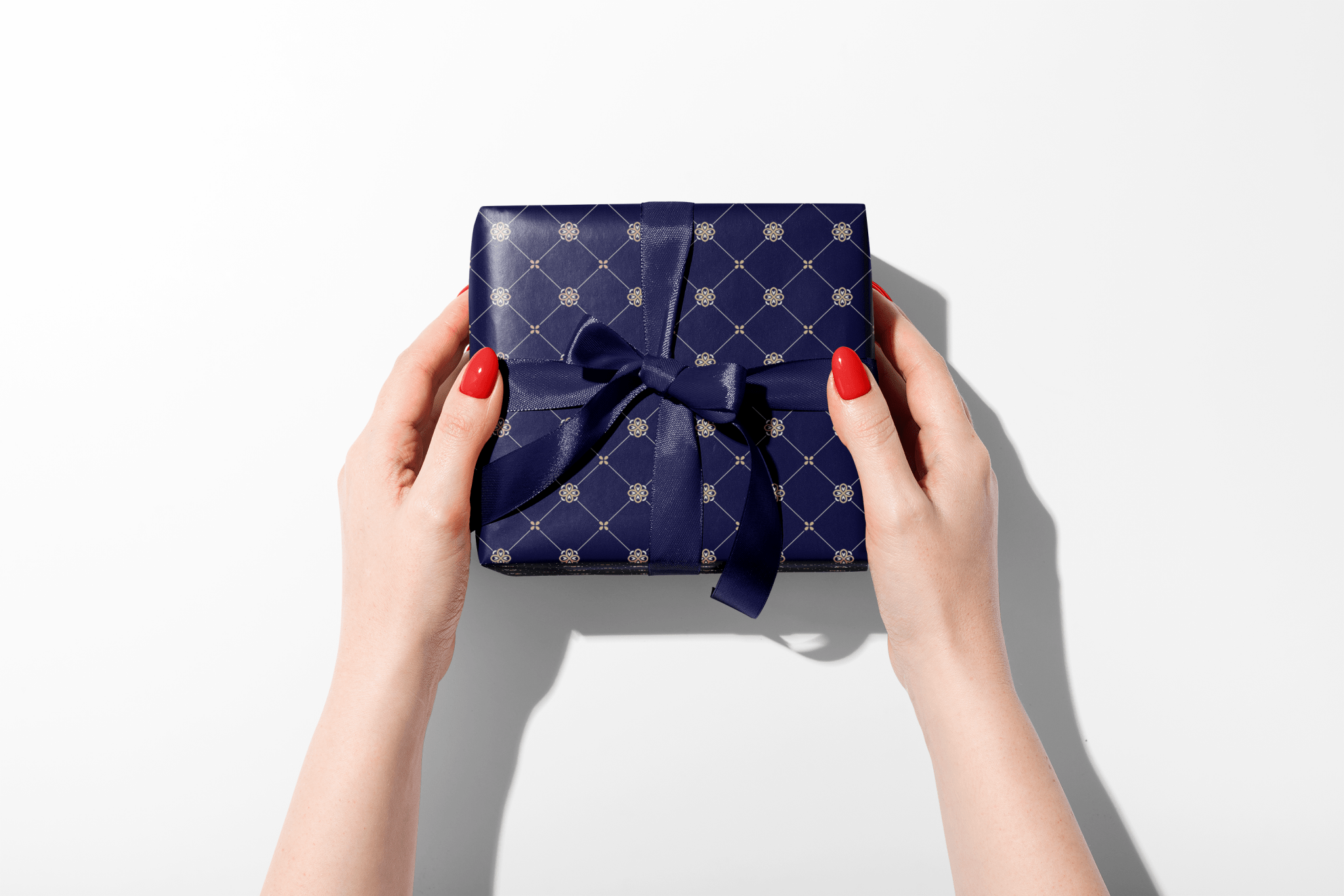 Blue gift box with a bow held by hands on a white background