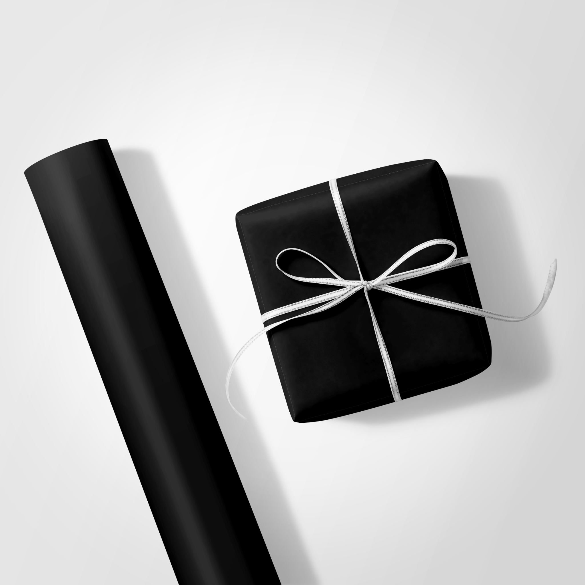 Black gift box with white ribbon on a light gray background