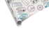 Cream-colored wrapping paper with a dense pattern of colorful vintage travel stamps and passport markings, ideal for mens wrapping paper and adventure themes.