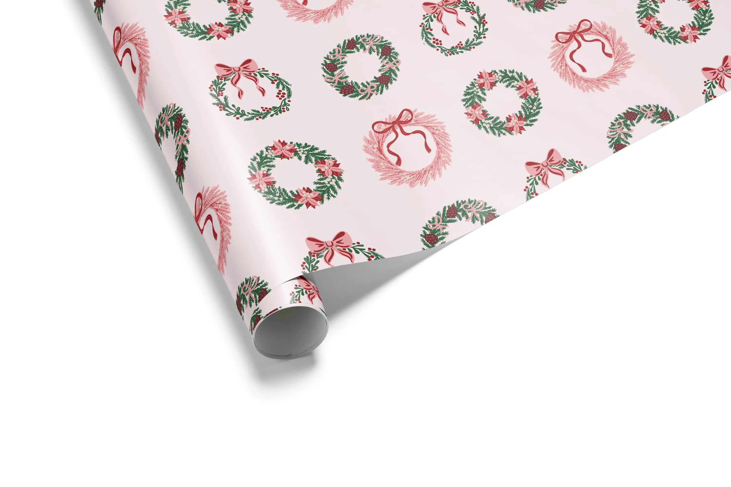 Alt Tag: Christmas Pink Wrapping Paper roll with festive wreath pattern, green foliage and red bows on light pink background