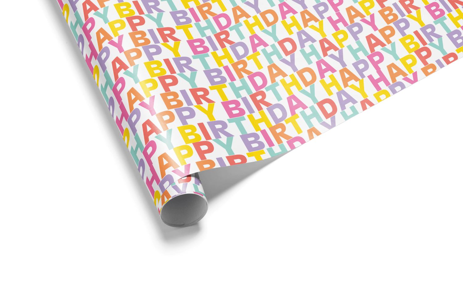 Dense, colorful happy birthday wrapping paper featuring the words "HAPPY BIRTHDAY" repeated in a mixed pastel rainbow typography pattern.