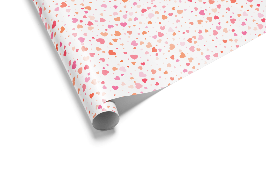 White wrapping paper covered in a dense, scattered pattern of tiny pink, blush, and coral hearts, ideal for Valentine&