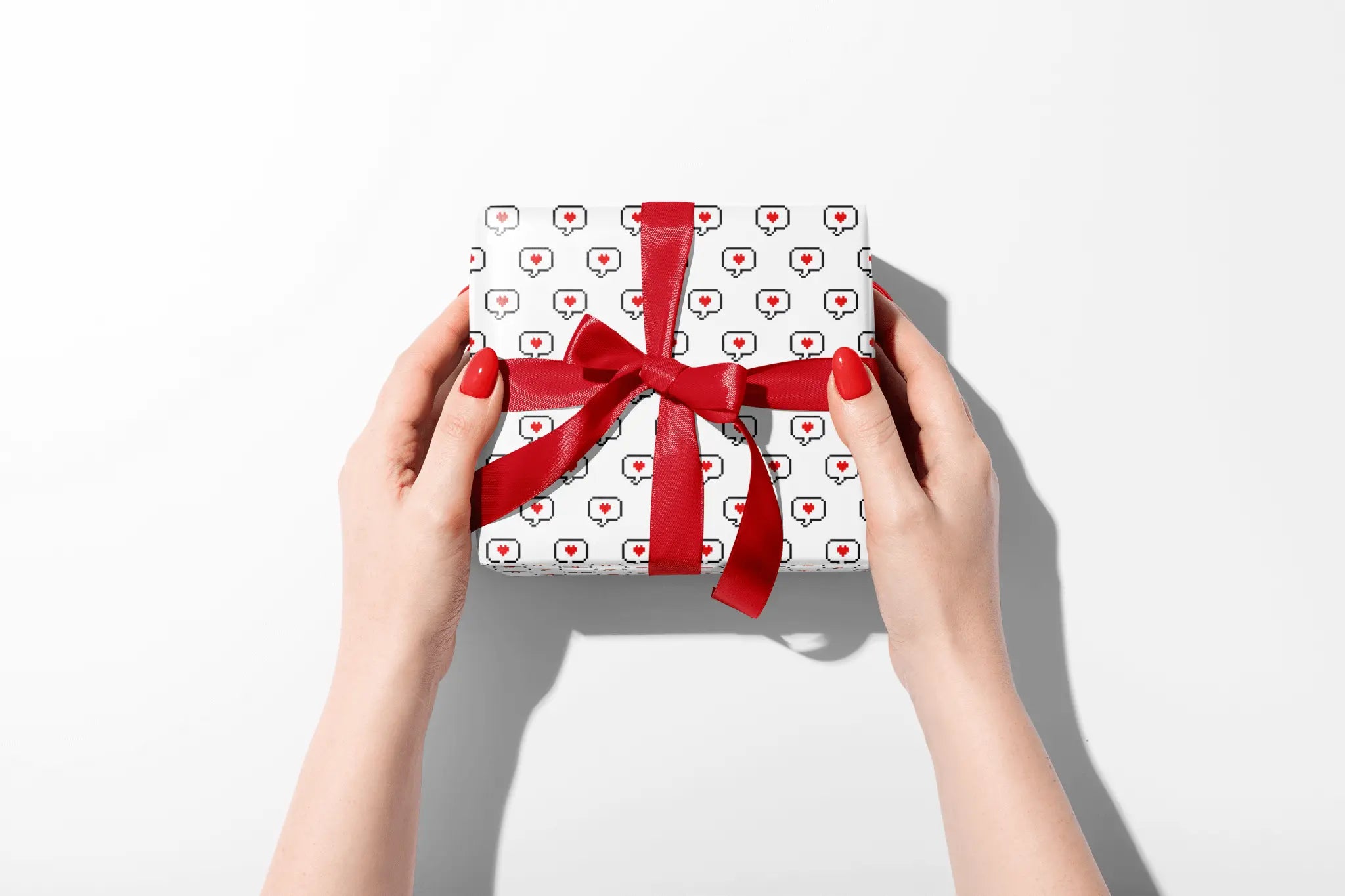 Haus of Wrap chic wrapping paper, perfect for birthdays, weddings, holidays—red-ribbon gift held by hands with red nails.