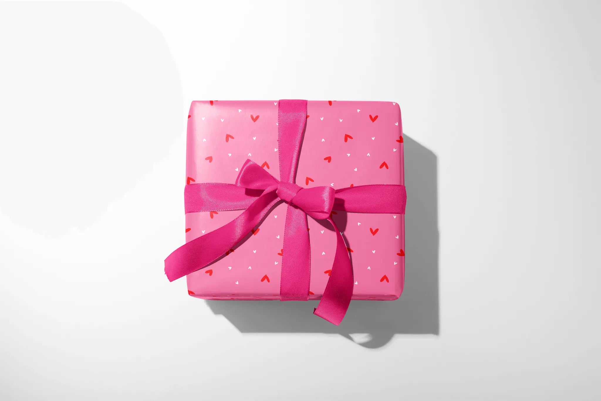 Cute Valentine Heart Wrapping Paper gift box wrapped in pink sweetheart confetti paper with hearts and hot pink ribbon