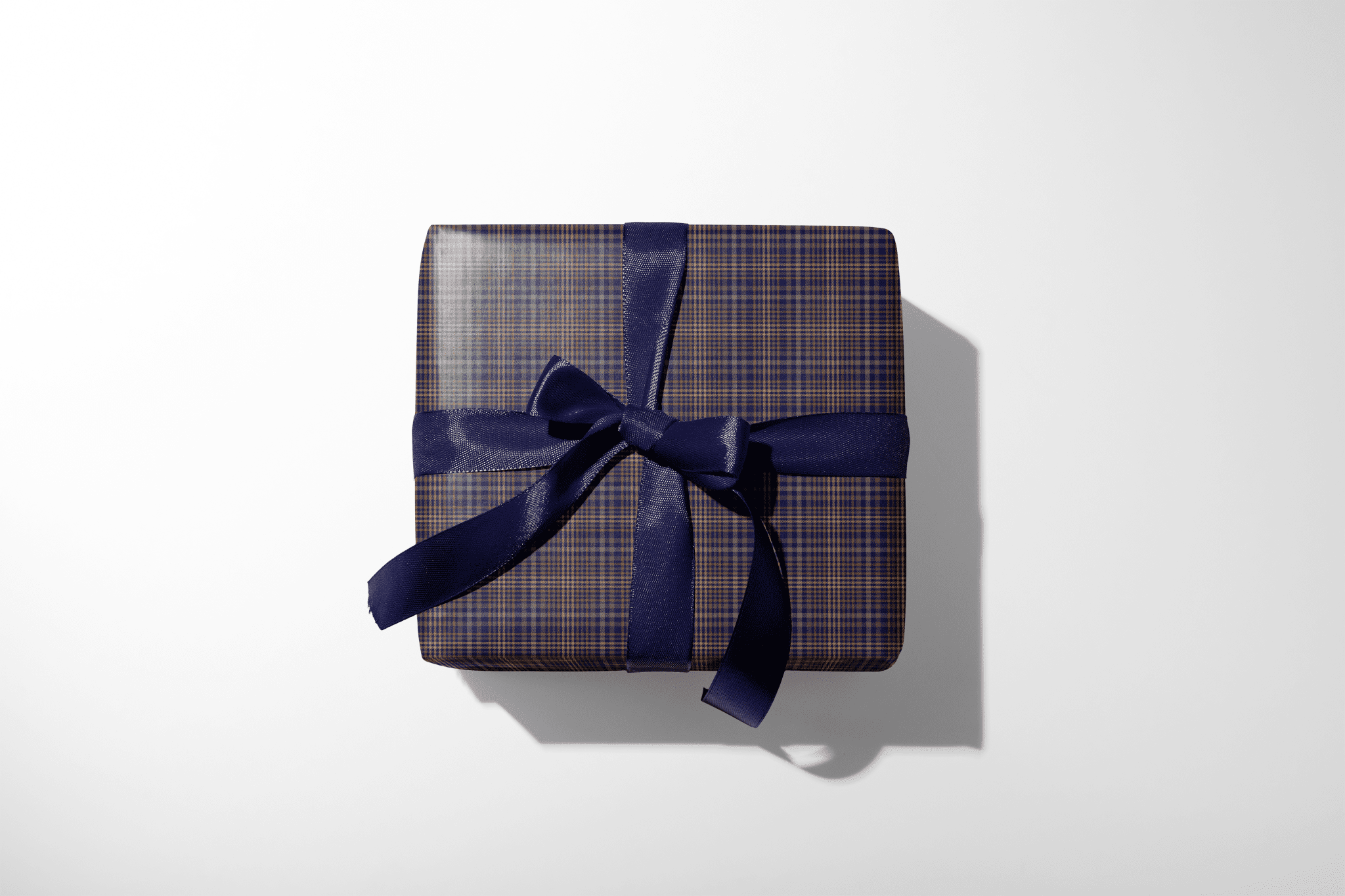 Gift box with plaid pattern and blue ribbon on a white background