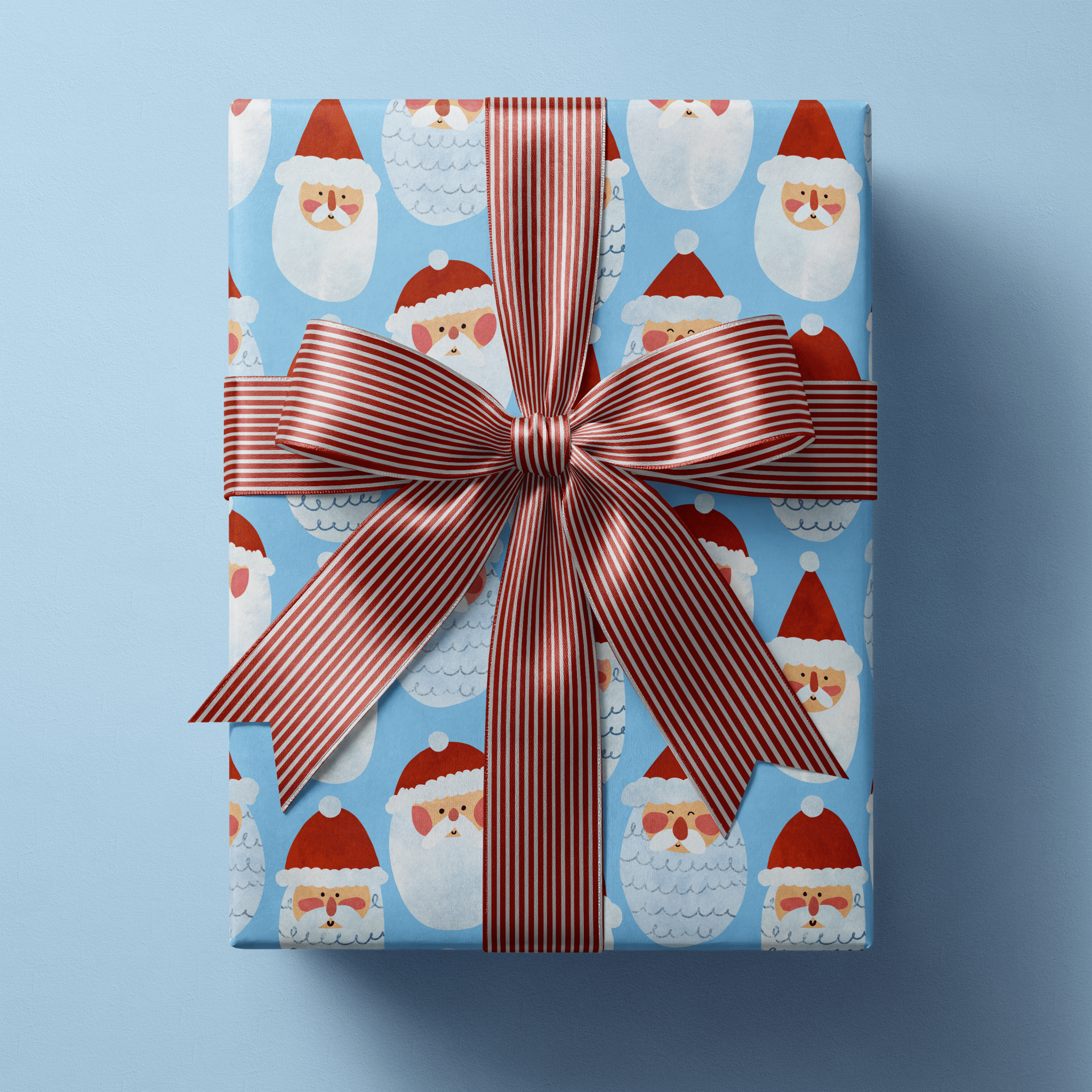 Santa Christmas wrapping paper with cheerful folk-drawn Santa faces in red hats on sky blue.