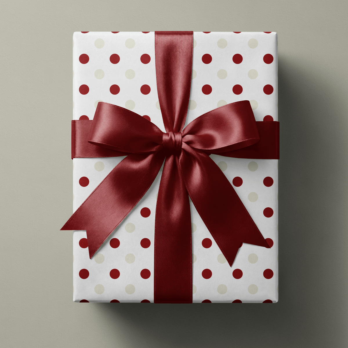 Polka dot Christmas wrapping paper with cranberry red and soft ivory dots scattered evenly across a crisp white ground.