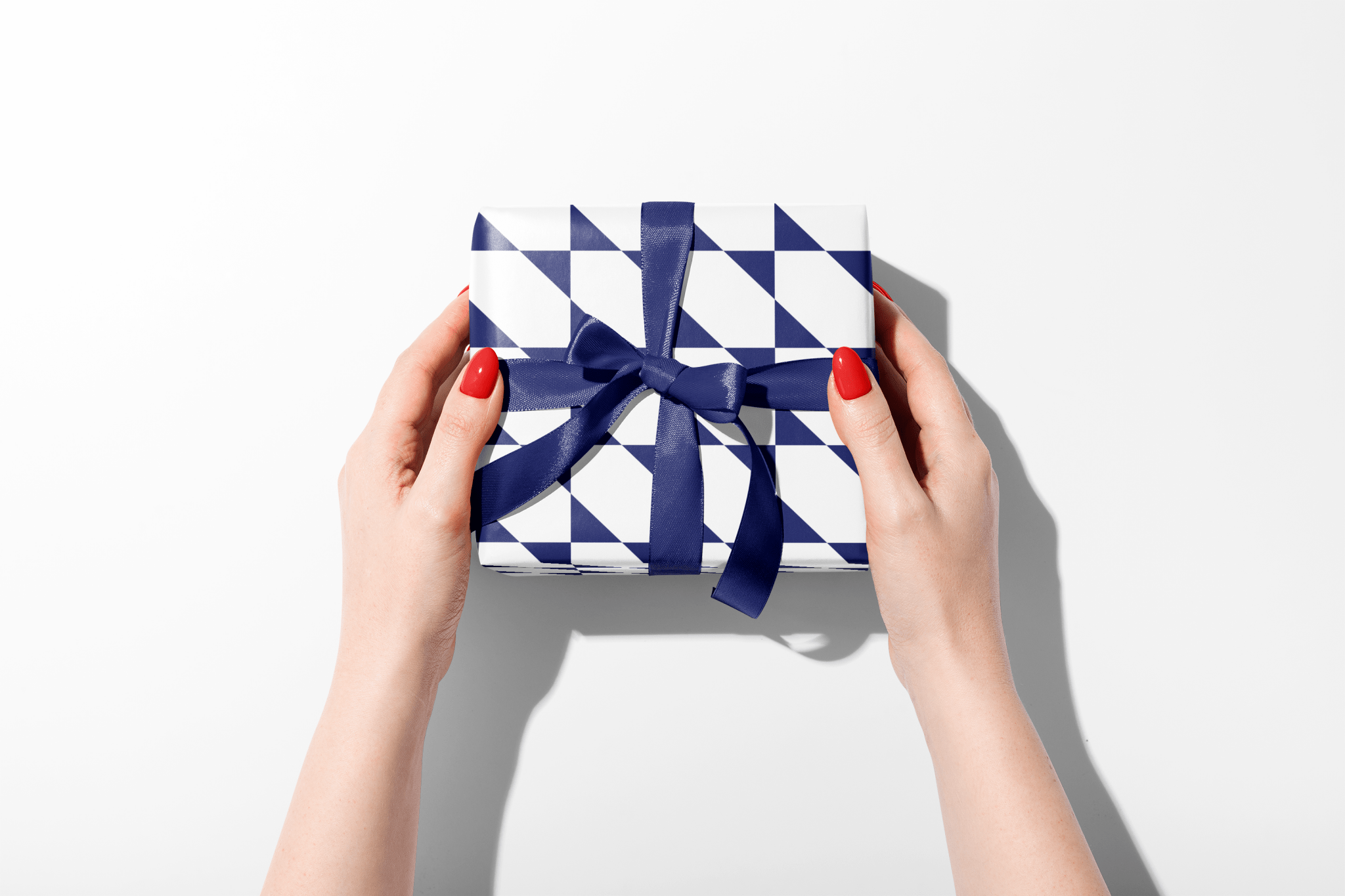 Gift box with blue ribbon held by hands on a white background
