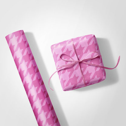 Pink houndstooth patterned gift wrap and a wrapped gift on a white background