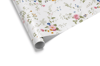 White wrapping paper with a detailed pattern of scattered, colorful wildflowers and roses on delicate green trailing vines, ideal for floral wrapping paper and elegant gifts.