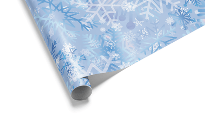 Christmas wrapping paper with an artistic, multi-layered pattern of watercolor snowflakes in shades of blue, lavender, and white, ideal for winter wonderland themes.