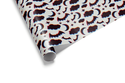 Halloween wrapping paper with bats, moons, clouds, and stars on a white background.