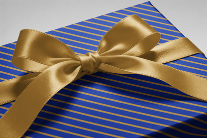 Alt Tag: Blue and Gold Wrapping Paper with diagonal gold stripes and satin gold ribbon bow, The Sovereign luxury gift wrap