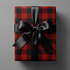 Buffalo Plaid Wrapping Paper in red and black tartan grid gift wrap with black satin ribbon bow, winter lodge holiday present