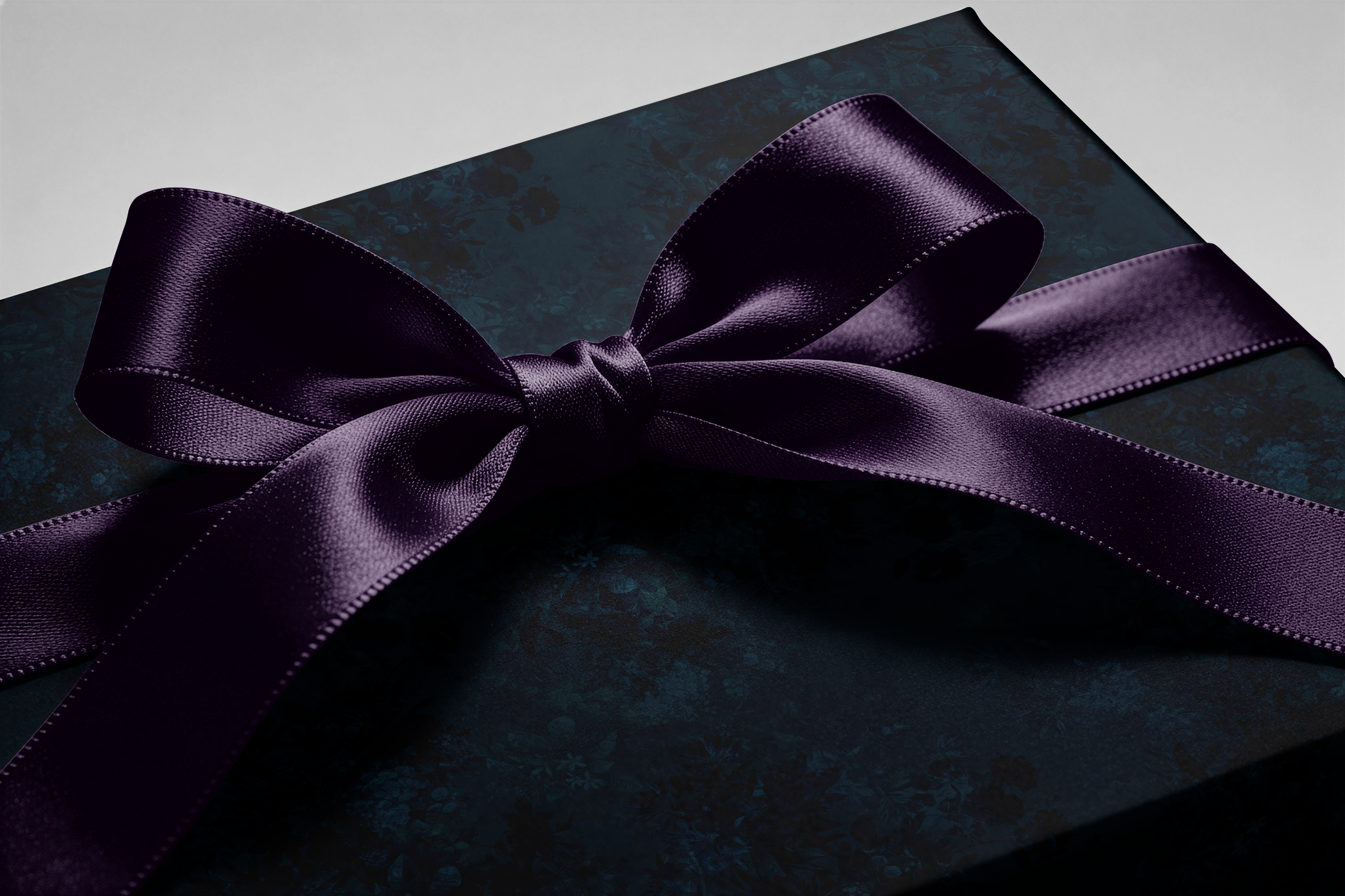 Alt Tag: Dark Floral Wrapping Paper Velvet Nocturne gift wrap with navy florals on inky blue backdrop, finished with satin purple ribbon bow