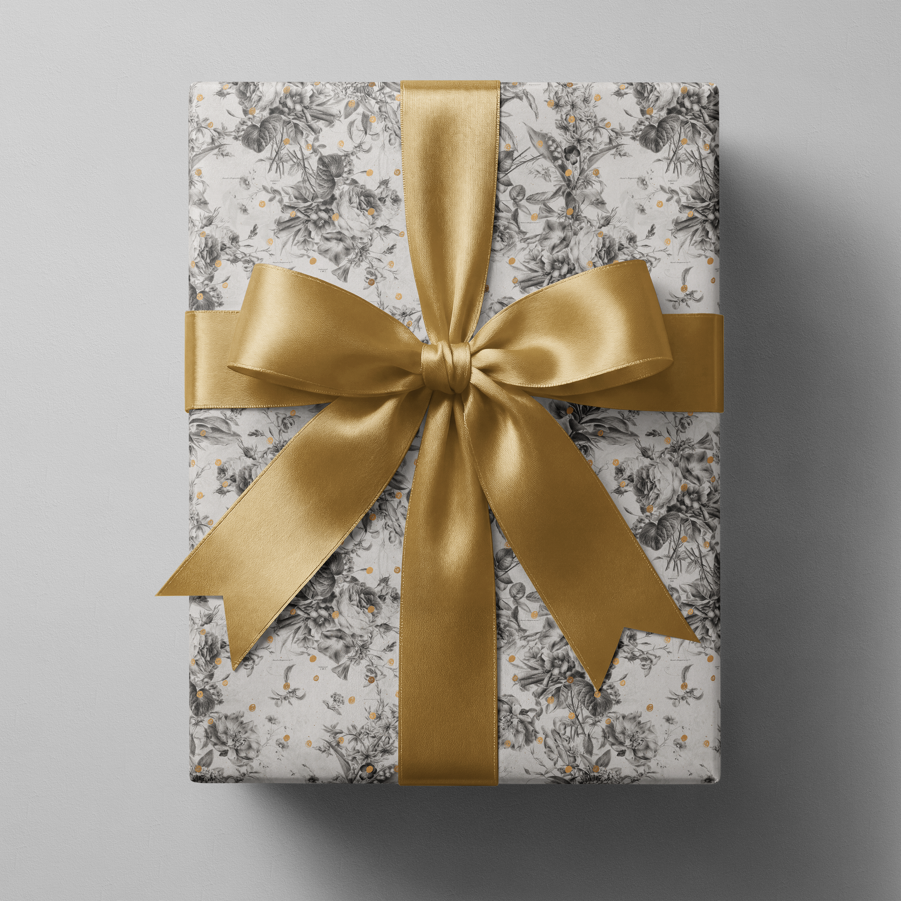Alt Tag: Black and White Floral Wrapping Paper with botanical sketches and gold speckles, wrapped gift with gold satin ribbon bow