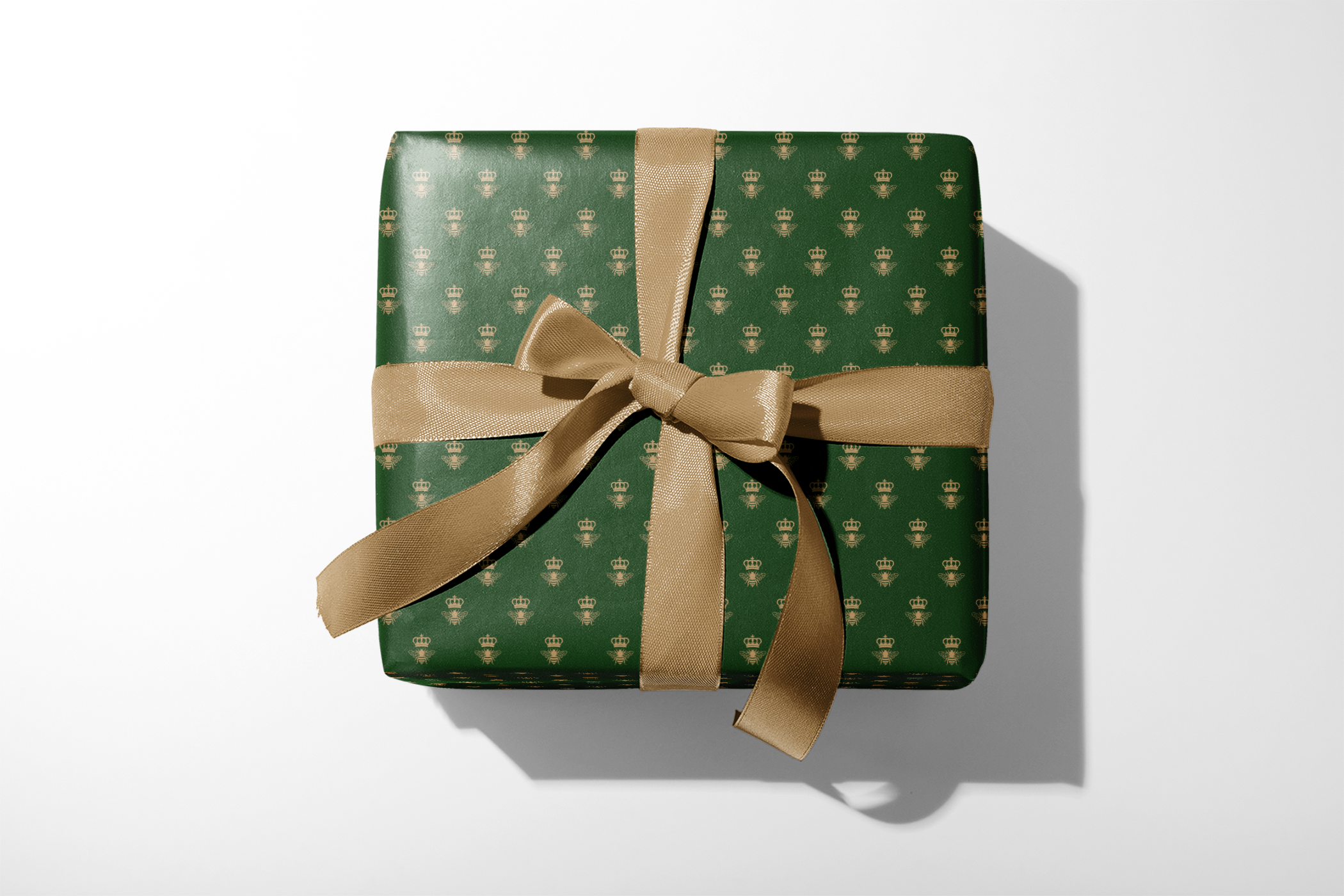 Green and Gold Wrapping Paper with crowned bee pattern on emerald gift wrap and gold ribbon bow, Emerald Monarch design