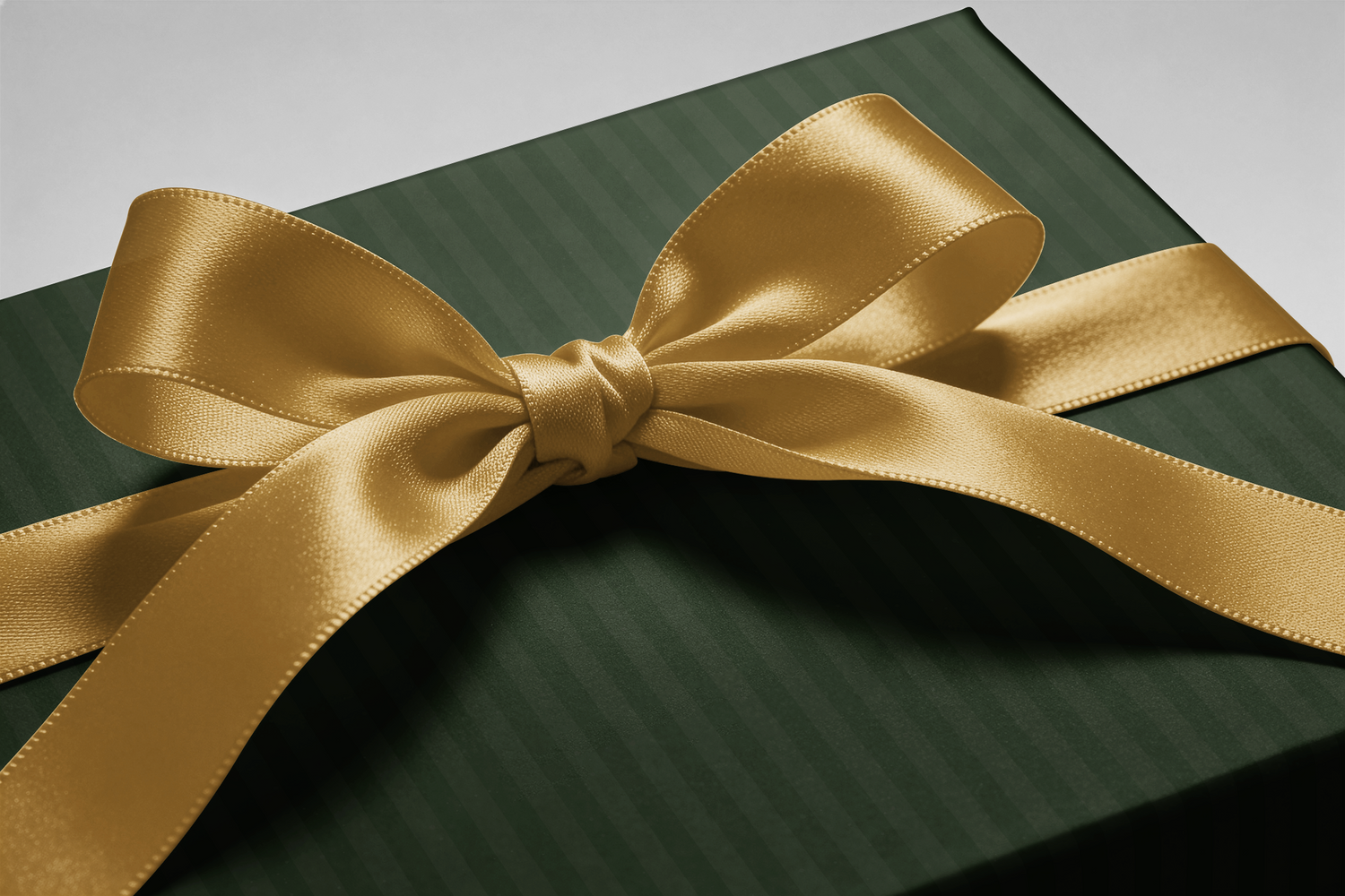 Alt Tag: Green Striped Wrapping Paper in deep forest and muted olive vertical stripes with a gold satin ribbon bow