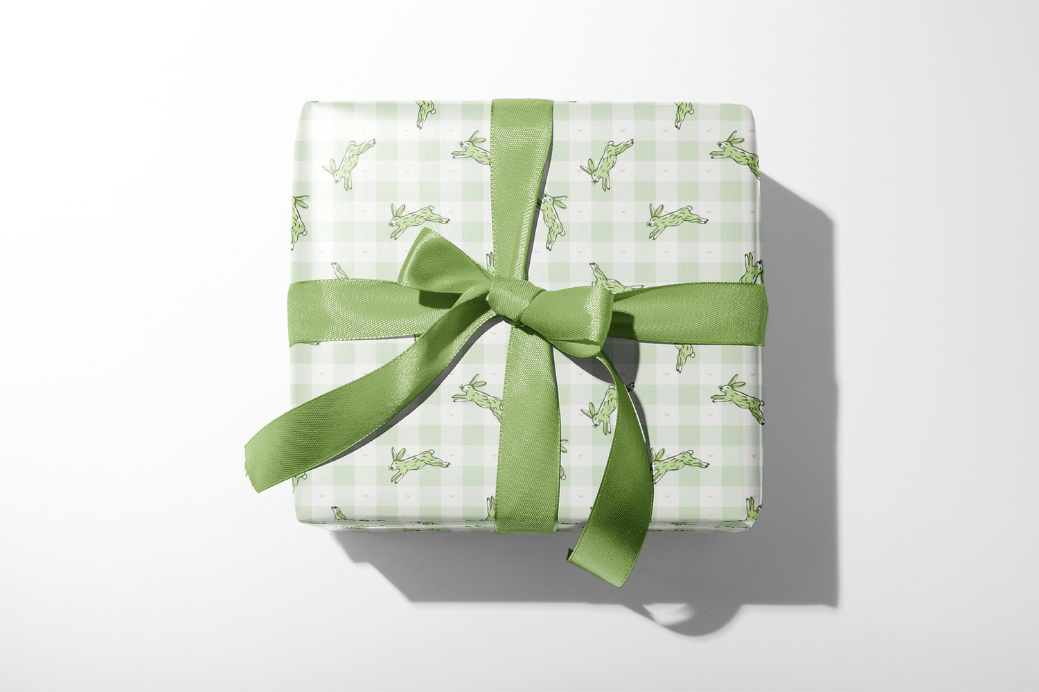 Alt Tag: Bunny Wrapping Paper with sage green gingham and running hare pattern, gift-wrapped with matching green ribbon