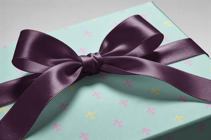Fleur de Lis Wrapping Paper in powder blue with pastel fleur-de-lis pattern and purple satin ribbon gift wrap