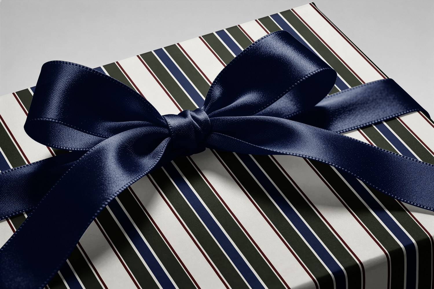 Alt Tag: Striped Wrapping Paper gift wrap with classic vertical stripes in forest green, navy, burgundy and cream, tied with satin navy bow