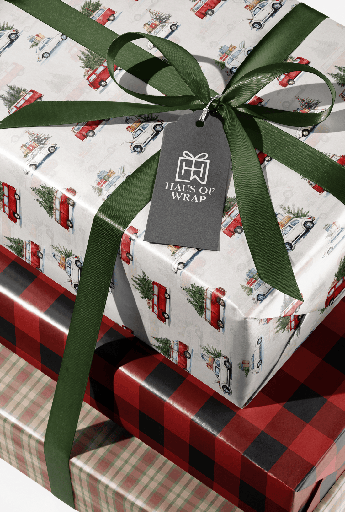 Vintage Christmas Car Wrapping Paper on gift boxes with red and cream cars, evergreen trees, plaid wrap, and dark green ribbon bow