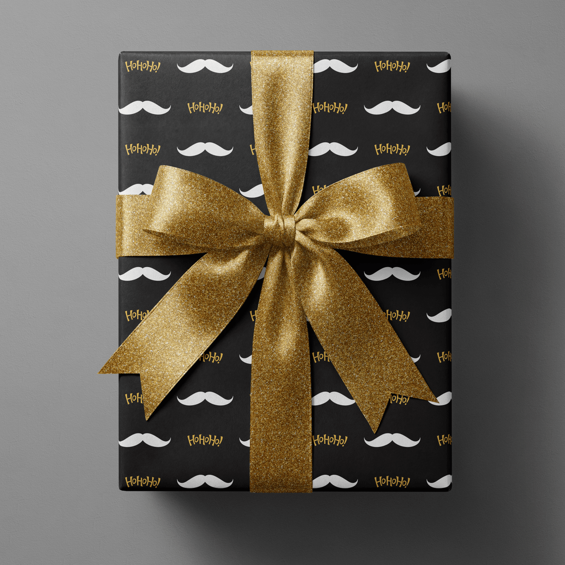 Black and gold wrapping paper christmas with white mustaches and gold Ho Ho Ho script.