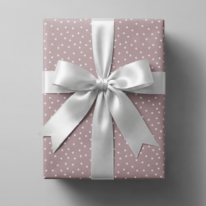 Polka dot wrapping paper pink with scattered white dots on a dusty mauve ground.