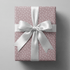 Polka dot wrapping paper pink with scattered white dots on a dusty mauve ground.