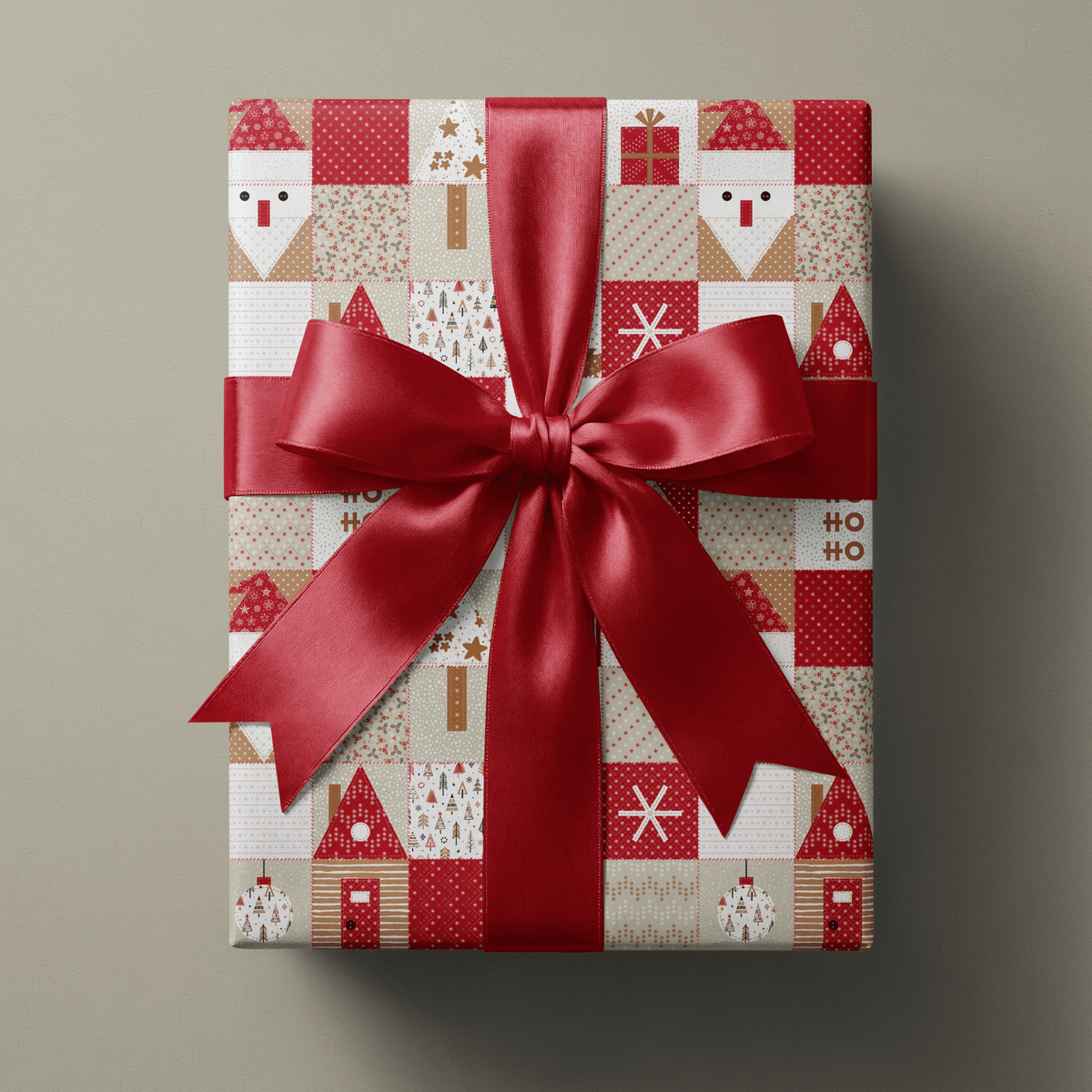 Rustic christmas wrapping paper with patchwork Santas, gingerbread houses, and star quilt blocks in red and cream.