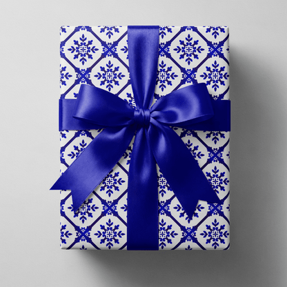 Blue and white christmas wrapping paper with a navy diamond lattice and snowflake medallions.