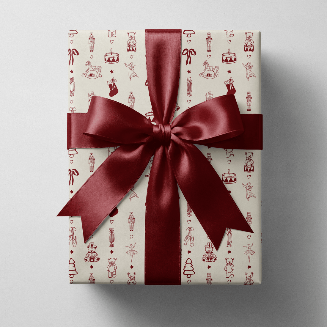 Toy soldier wrapping paper with nutcrackers, rocking horses and ballerinas in cream and burgundy — nostalgic, collectible and ready to wrap under the tree.