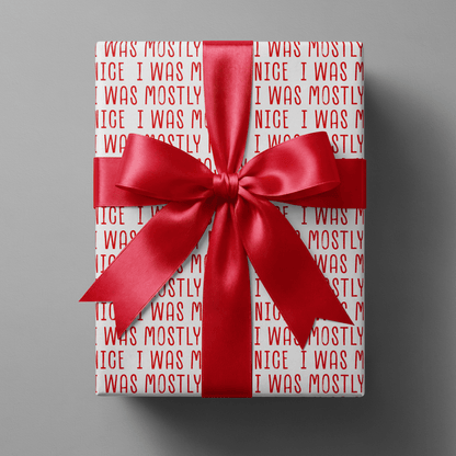Naughty christmas wrapping paper with repeating bold red "I was mostly nice" text on white.