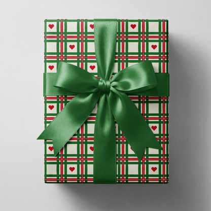 Plaid christmas wrapping paper with hand-drawn green and red lines and small red hearts.