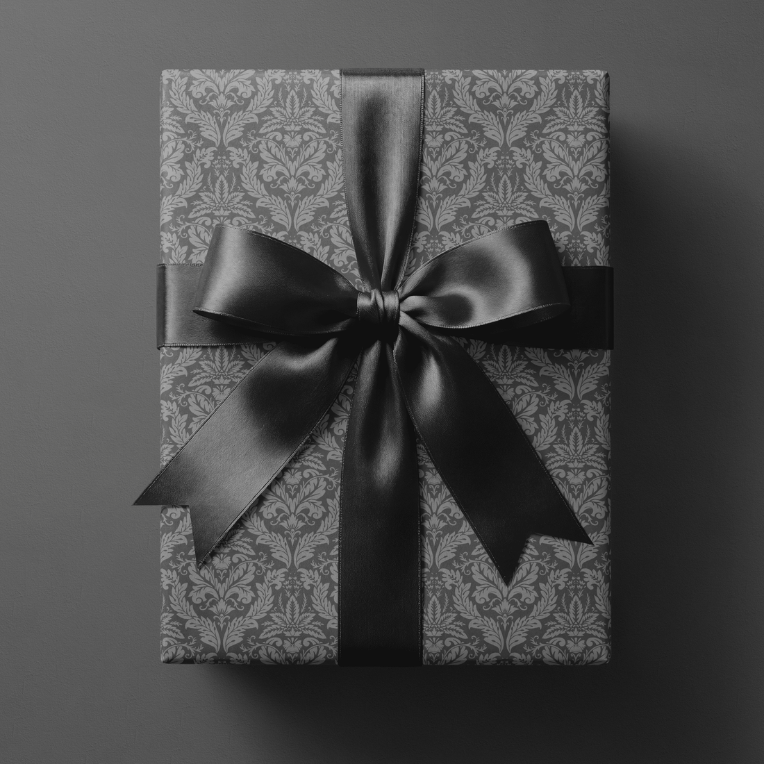 Gift wrapped in grey victorian wrapping paper with a black ribbon bow