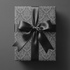Gift wrapped in grey victorian wrapping paper with a black ribbon bow