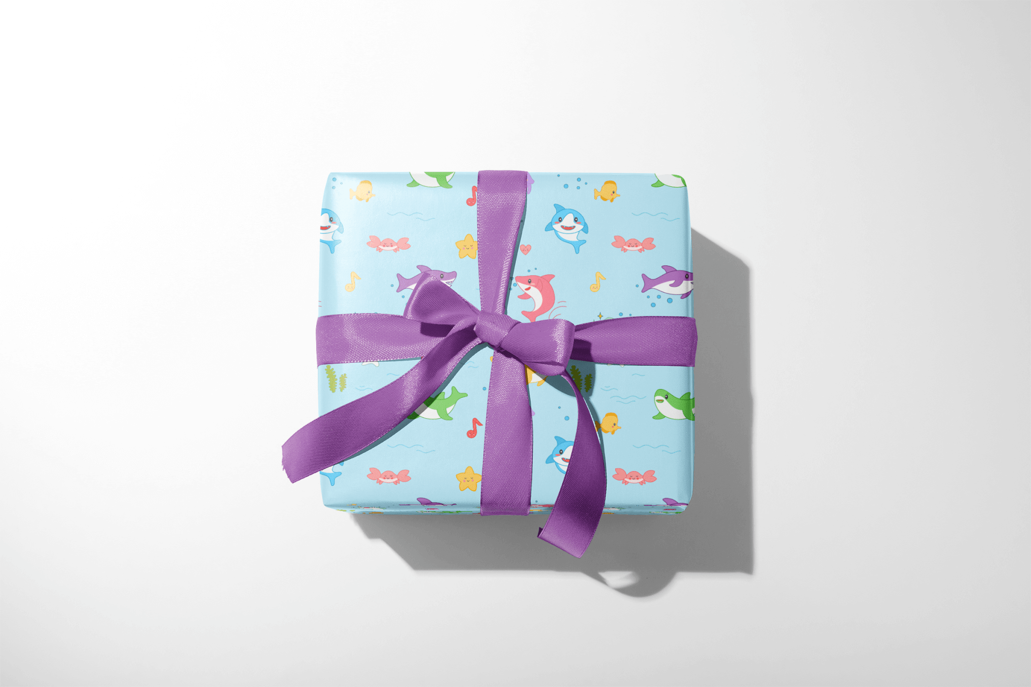 Alt Tag: Baby Shark Wrapping Paper gift wrap with colorful sharks and musical notes, wrapped present with purple ribbon