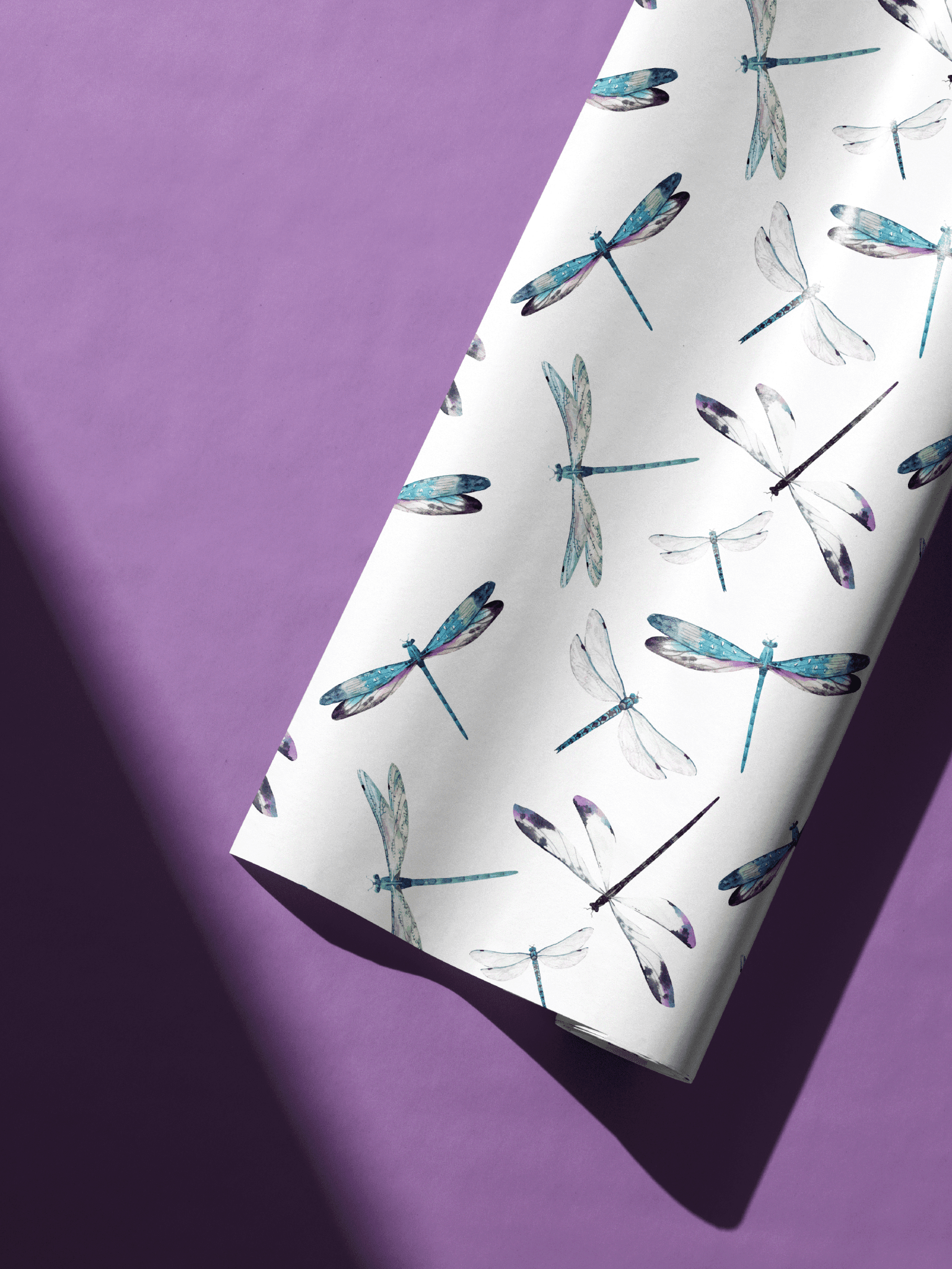 Dragonfly Themed Gift Wrap Paper with blue dragonfly pattern on white wrapping paper roll on purple background