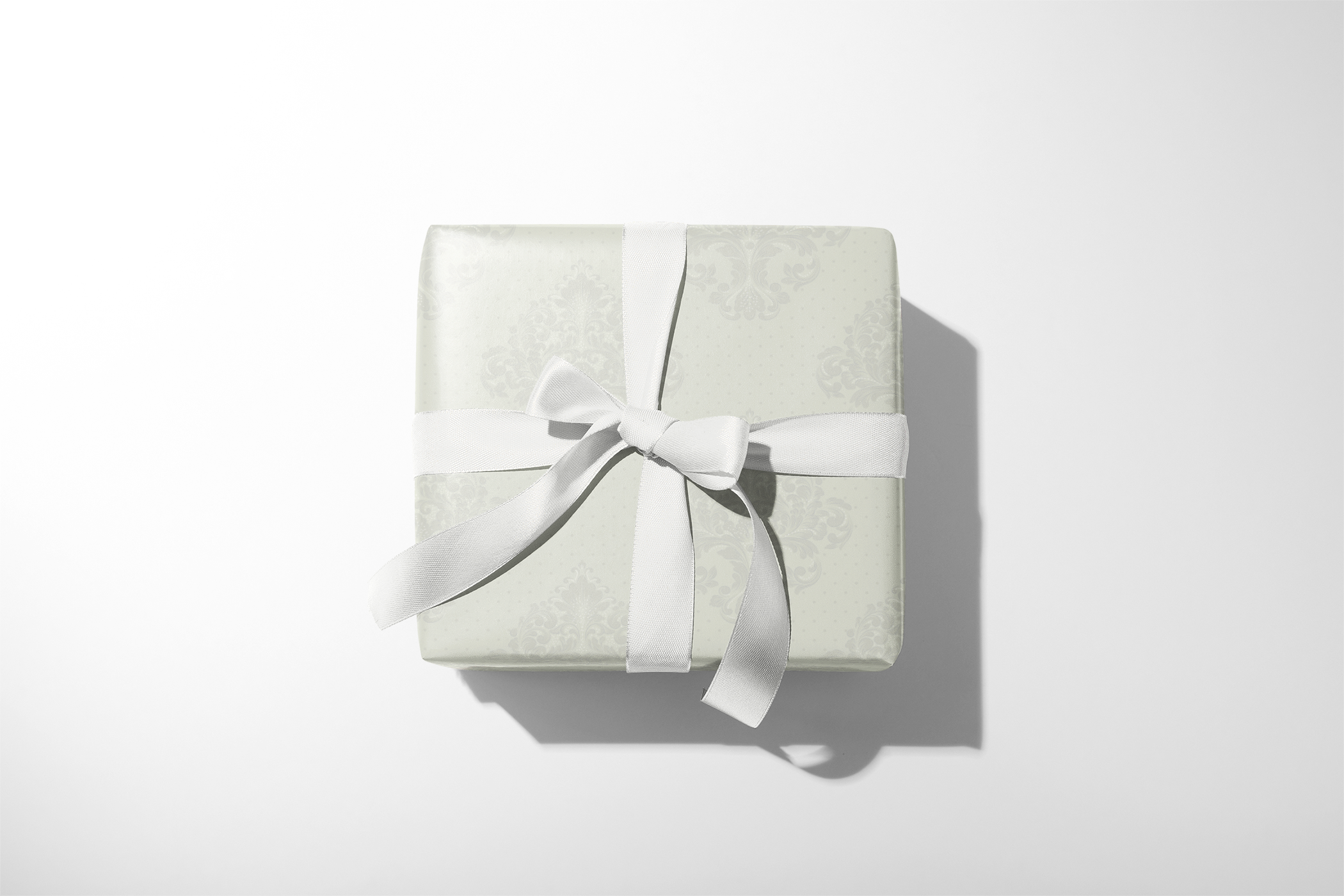 Alt Tag: Bridal Shower Gift Wrap in soft ivory damask pattern with white ribbon, elegant bridal shower gift wrapping paper