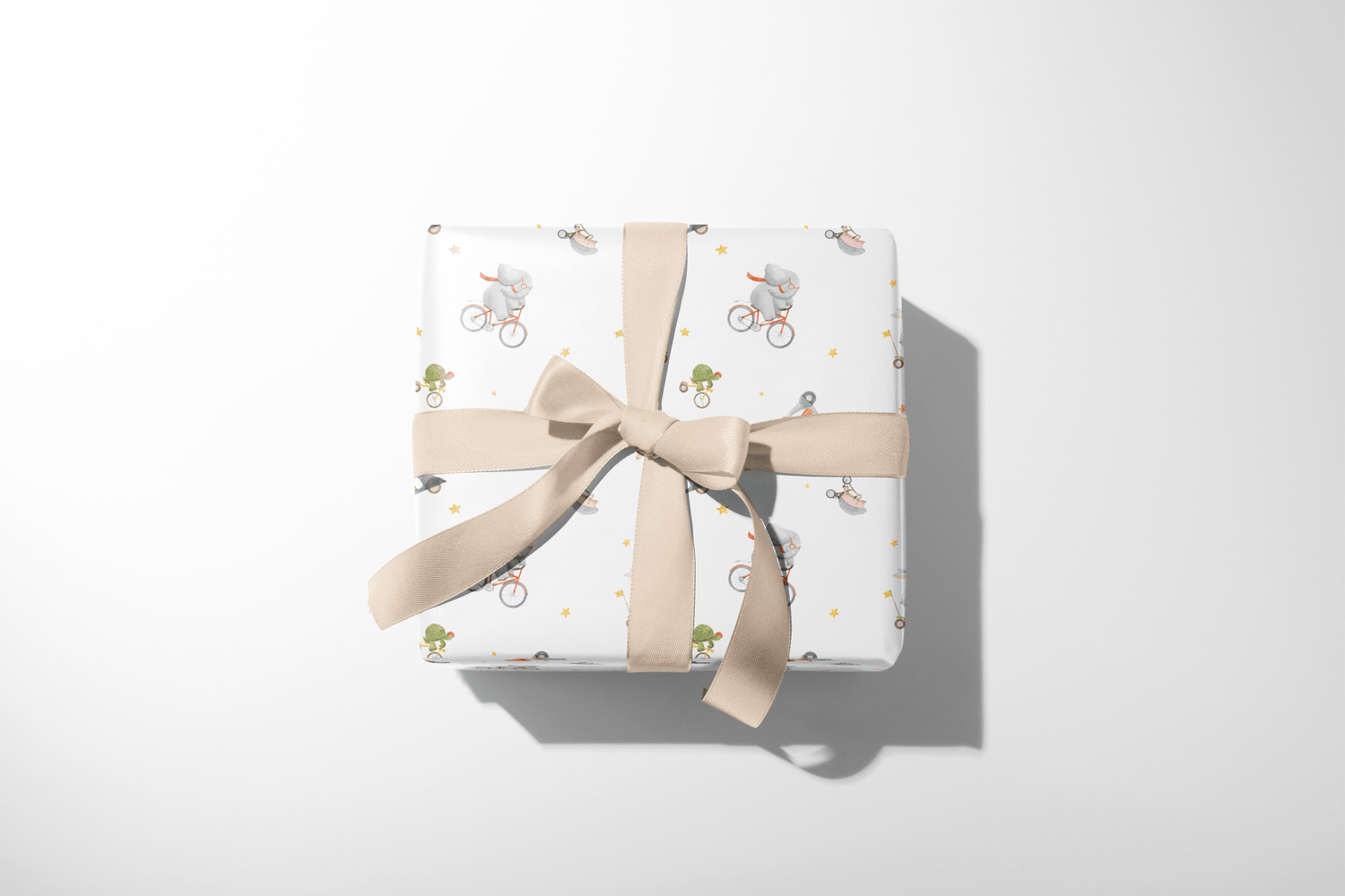 Alt Tag: Wild Wheels Adventure Wrap gift wrapping paper with safari animals on bicycles, wrapped present with beige ribbon